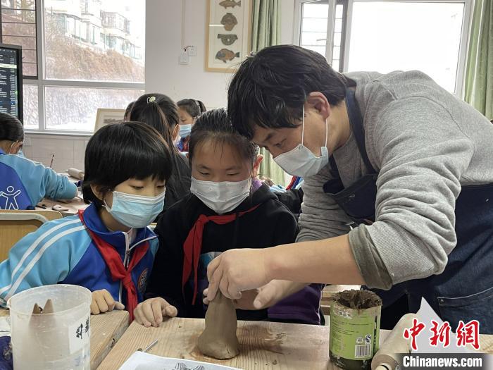 圖為西寧市勞動(dòng)路小學(xué)教師賈煜與學(xué)生一起制作陶藝?！≈苋鸪阶?攝