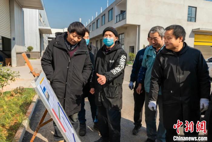 員工圍在展板前了解就地過年相關(guān)政策。婺城宣傳部供圖