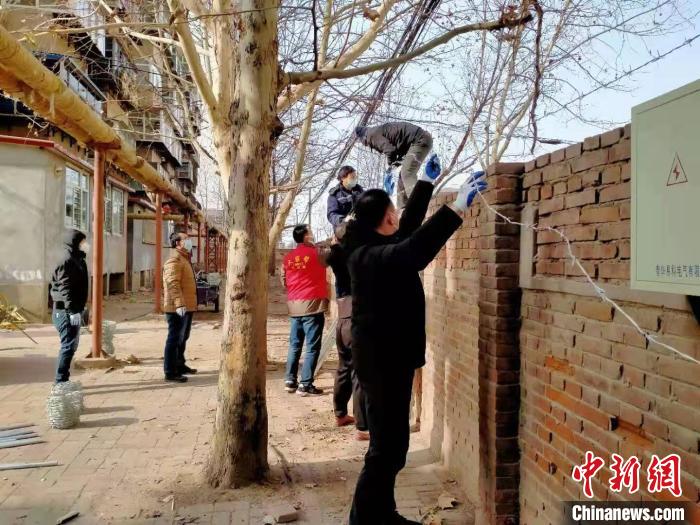 圖為小區(qū)志愿者為小區(qū)圍墻加裝倒刺鐵網(wǎng)?！〈迺?攝