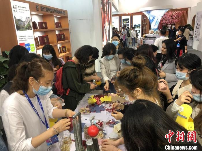 溫州文博會(huì)上，觀展者正在制作零錢包、小提包?！∨饲呶?攝