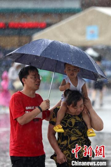 市民冒雨前行?！°蟛?攝