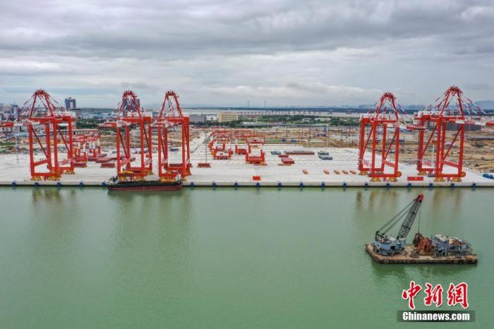 6月23日，廣東省廣州市，廣州港南沙四期碼頭實(shí)船聯(lián)合調(diào)試成功。該碼頭采用“單小車自動(dòng)化岸橋、北斗導(dǎo)航無人駕駛智能集卡、堆場(chǎng)水平布置側(cè)面裝卸、港區(qū)全自動(dòng)化”運(yùn)作方案，是粵港澳大灣區(qū)首個(gè)全自動(dòng)化碼頭。(無人機(jī)照片) <a target='_blank' href='http://www.chinanews.com/'>中新社</a>記者 陳驥旻 攝 