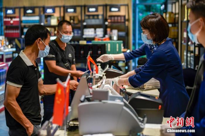 資料圖：工作人員給顧客結賬。 <a target='_blank' href='http://www.chinanews.com/'>中新社</a>記者 駱云飛 攝