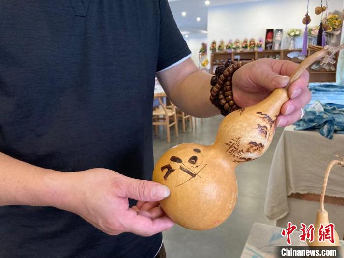 陶思俊展示自己創(chuàng)作的葫蘆烙畫?！￡愳o 攝