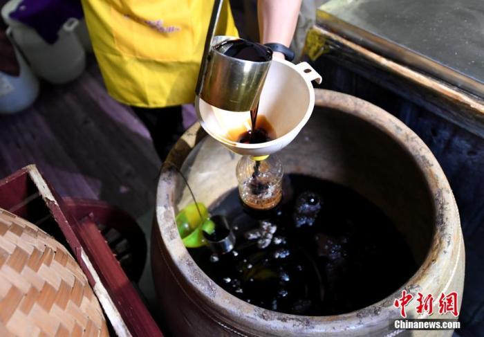 圖為工人將做好的醬油進行罐裝。 王東明 攝