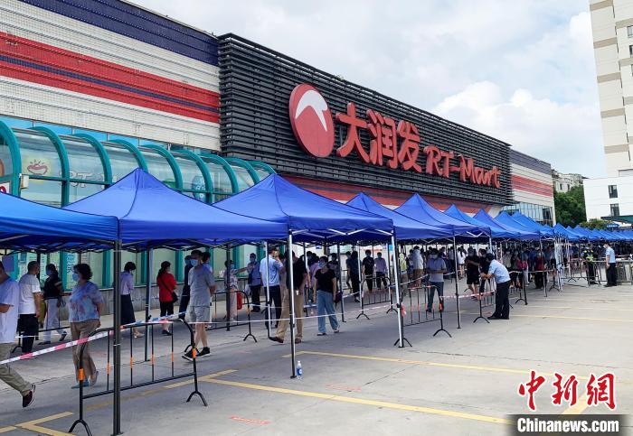 民眾排著長(zhǎng)長(zhǎng)的隊(duì)伍，在工作人員的指引下，等待進(jìn)入超市購(gòu)物?！〈藜衙?攝