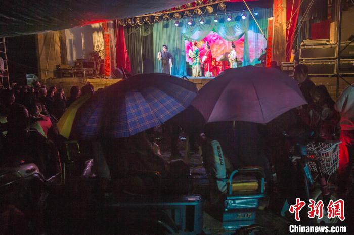 民眾在雨中觀看蒲劇?！∥淇〗?攝