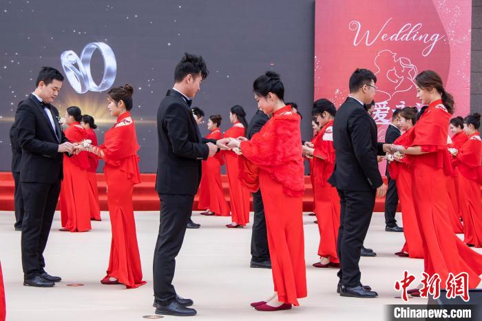 圖為新人們在集體婚禮現(xiàn)場交換婚戒。　王威 攝