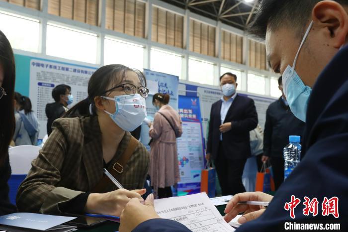 圖為南昌大學前湖校區(qū)校園招聘活動現(xiàn)場，一名大學生正在求職現(xiàn)場填寫報名表。　劉占昆 攝