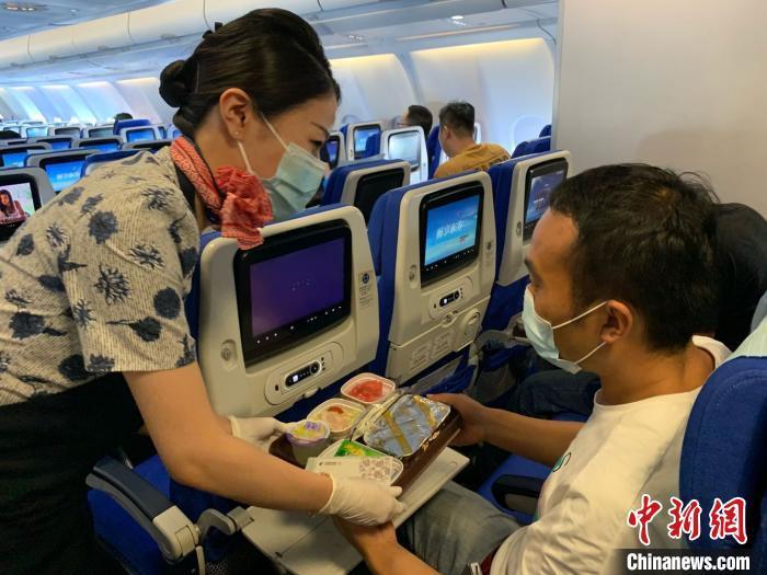乘務(wù)員向旅客提供熱餐。東航供圖