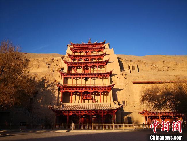 圖為2020年11月7日，晨光沐浴中的莫高窟標(biāo)志性建筑“九層樓”。(資料圖)