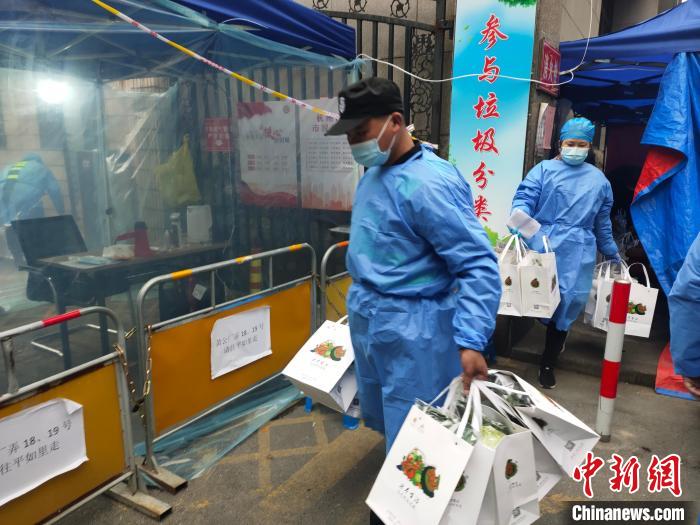 杭州一封閉管理小區(qū)，工作人員為居民配送愛心蔬菜。　王逸飛 攝
