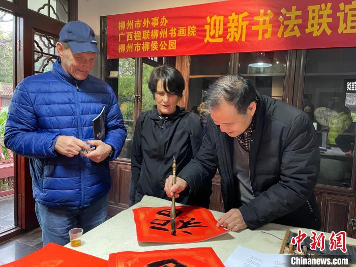 柳州市一書法家教兩位英國人書寫春聯(lián)?！×周?攝