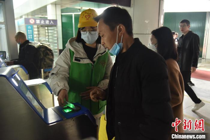 圖為志愿者協(xié)助乘客?！№n毅 攝