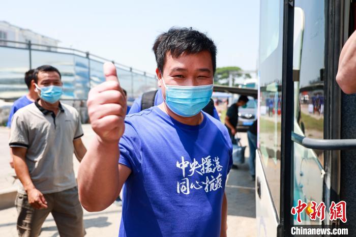 建設(shè)者們身穿文化衫，帶著燦爛的笑容離開駐地?！≠Z凱 攝