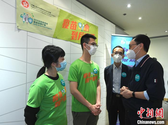 聶德權(quán)(右一)與“疫苗到戶接種服務(wù)”工作人員交談，了解他們的工作?！∠愀厶貐^(qū)政府新聞處供圖