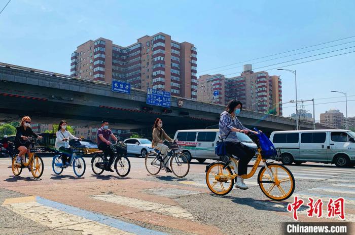 5日，北京東三環(huán)附近正騎單車出行的市民。