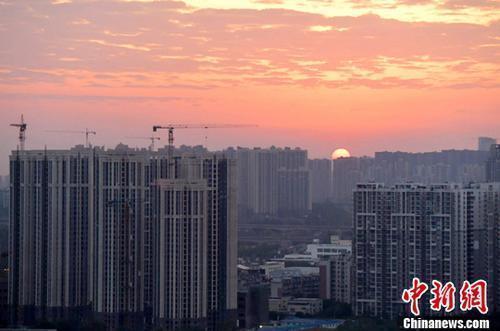 資料圖：城區(qū)一角，太陽(yáng)正從東方升起。<a target='_blank' href='/'>中新社</a>記者 劉忠俊 攝