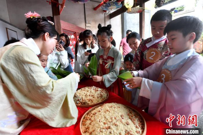 圖為兩岸親自家庭體驗(yàn)釣包粽子?！蚊?攝