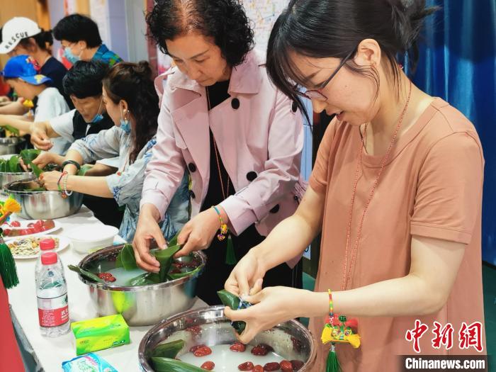 在寧港澳臺同胞與社區(qū)居民一起包粽子?！幭母郯呐_辦 供圖