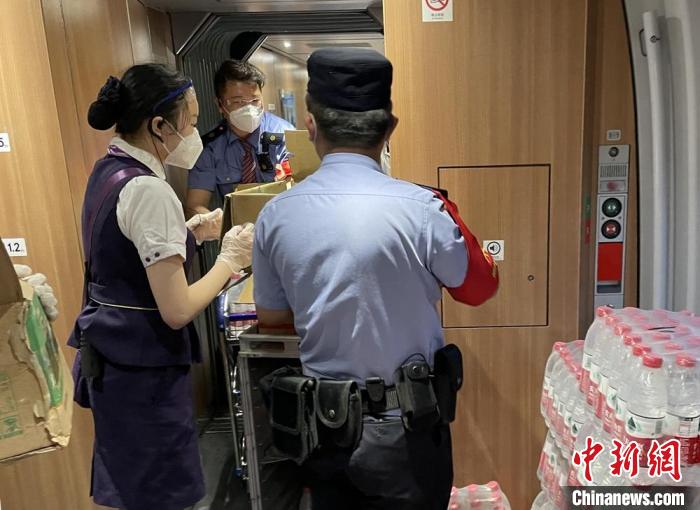 乘警與列車(chē)工作人員一起運(yùn)送礦泉水。　徐州鐵路公安處供圖