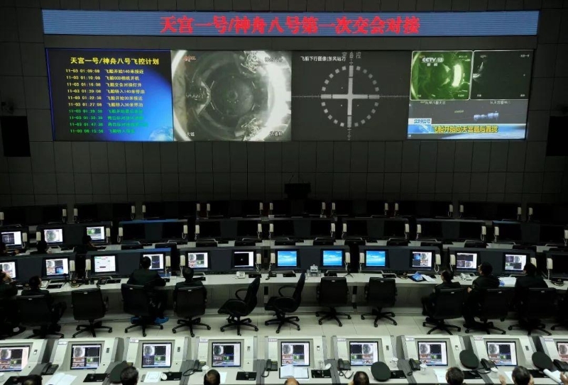 2011年11月3日凌晨，在酒泉衛(wèi)星發(fā)射中心指控大廳，技術(shù)人員通過(guò)大屏幕觀看天宮一號(hào)與神舟八號(hào)飛船對(duì)接全程。（圖源：央視新聞）