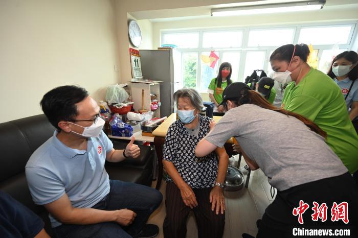 聶德權(quán)(左一)鼓勵一位居于香港坪洲的80多歲長者(左二)接種第二劑新冠疫苗?！∠愀厶貐^(qū)政府新聞處供圖