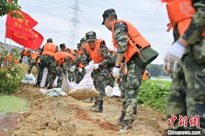 武警江西總隊(duì)機(jī)動(dòng)支隊(duì)官兵奔赴江西景德鎮(zhèn)市樂平市開展搶險(xiǎn)救援，傳遞沙袋。　彭丁 攝