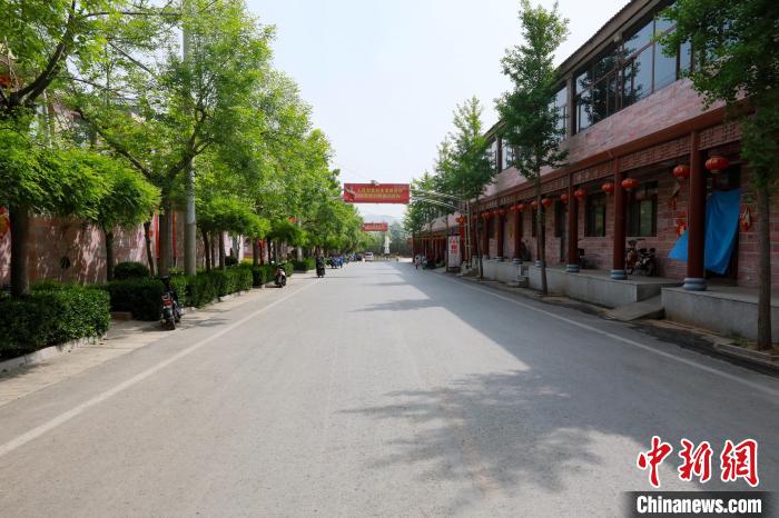 前南峪村干凈整潔、綠樹成蔭的街道，路兩側(cè)是村民住的二層樓房?！堸i翔 攝
