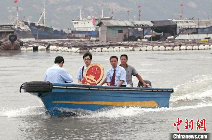 三都海上巡回法庭設(shè)立之初，法官們帶著國徽、坐著快艇，到漁排上審理、調(diào)解案件?！〗冻菂^(qū)法院 供圖
