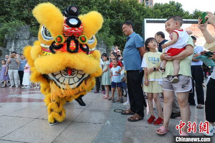 賴翊凡(獅頭)與李洪江配合在縣城詩鄉(xiāng)廣場練習(xí)舞獅吸引市民觀看?！■暮陚?攝