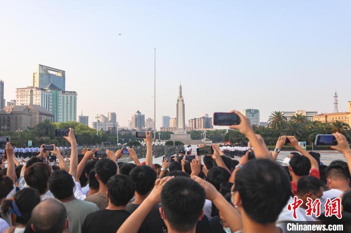 圖為不少市民在八一廣場上觀看升旗儀式?！⒘巍z
