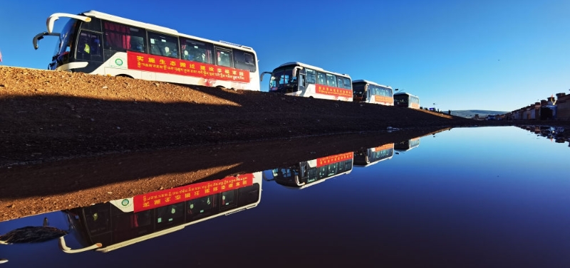 在西藏那曲市雙湖縣多瑪鄉(xiāng)拍攝的整裝待發(fā)的車隊，客車載著牧民前往位于山南市貢嘎縣的森布日安置點(2022年7月19日攝)。新華社記者 沈虹冰 攝