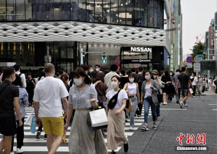 資料圖：日本當?shù)孛癖娕宕骺谡肿哌^東京街頭。 <a target='_blank' href='/'>中新社</a>記者 呂少威 攝