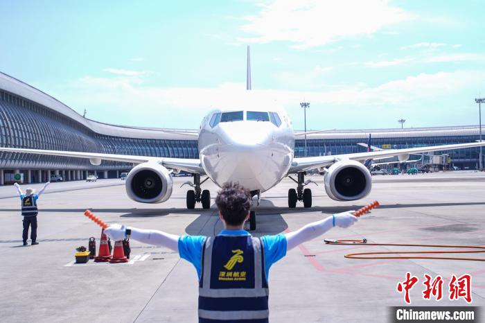 圖為機務(wù)人員引導飛機停靠?！￡惞谘?攝