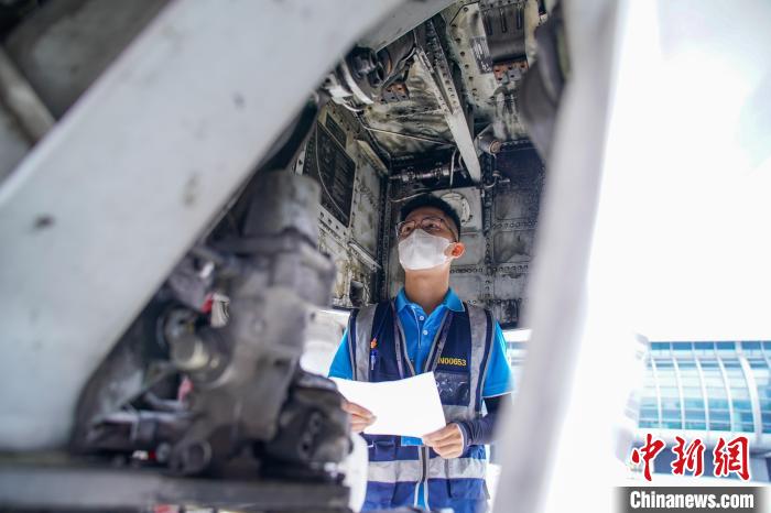 圖為航線維護工程師對飛機進行檢查。　陳冠言 攝