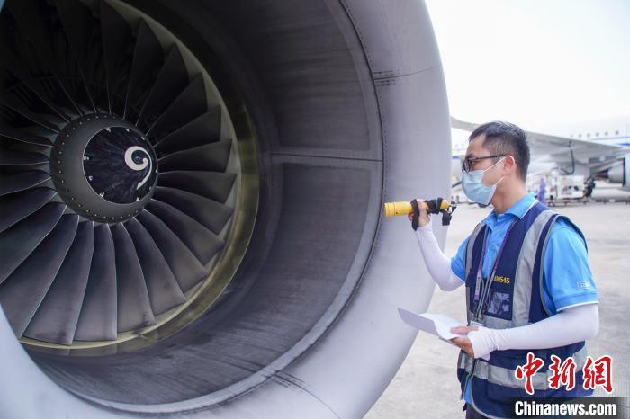 圖為航線維護工程師對飛機發(fā)動機進行檢查。　陳冠言 攝