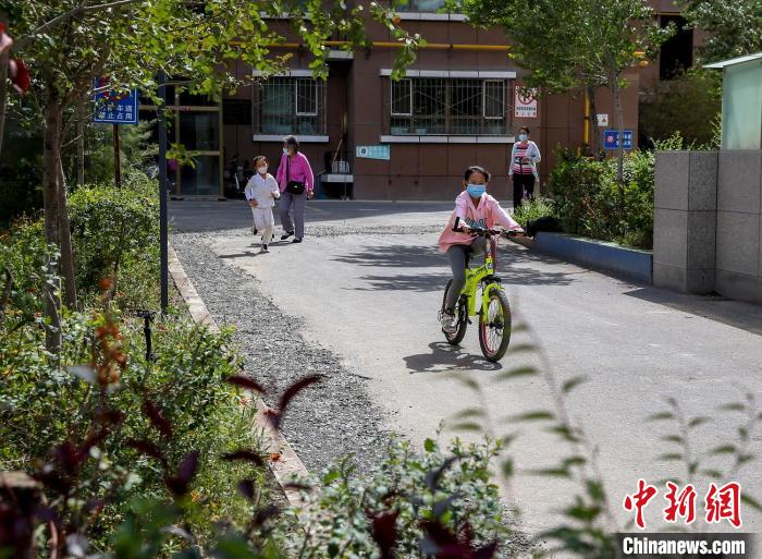 烏魯木齊市水磨溝區(qū)七道灣東街南社區(qū)，居民下樓在小區(qū)內(nèi)活動(dòng)。　鐘欣 攝