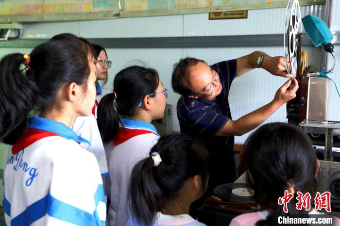 圖為肖光合向參觀的學(xué)生演示老式放映機(jī)的使用?！∩筹w 攝