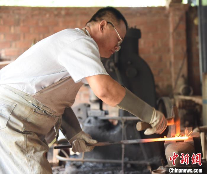王二兵在對(duì)燒制的劍進(jìn)行鍛打。　高占峰 攝