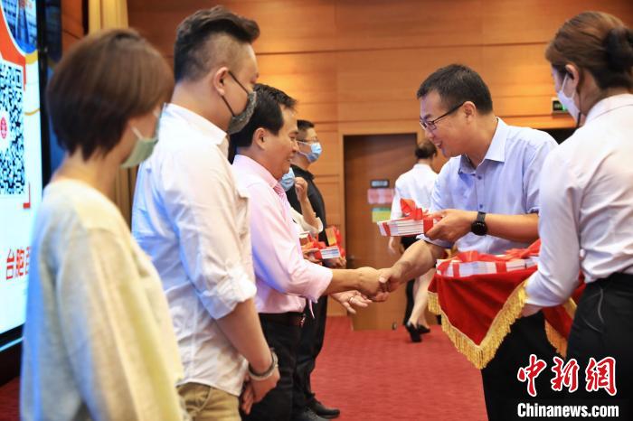 8月25日，北京市臺(tái)辦向臺(tái)胞代表贈(zèng)送《臺(tái)胞百問(wèn)》手冊(cè)?！±钛┓?攝