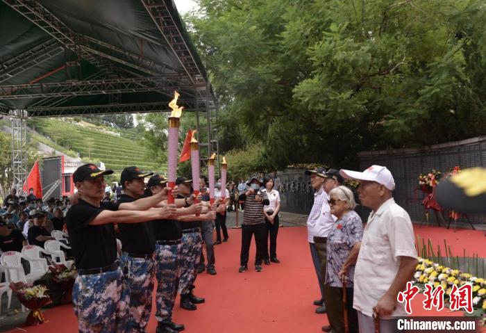抗戰(zhàn)志士后人從百歲老兵手中引燃火炬，點亮長明火?！＄娦?攝
