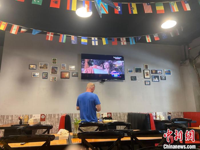 走進(jìn)店里，掛在天花板的各國(guó)國(guó)旗映入眼簾，電視中正播放著印度電影。　劉玉潔 攝