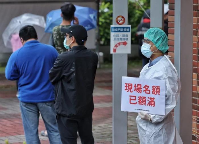 資料圖：臺灣快篩站現(xiàn)場名額額滿，醫(yī)護(hù)人員于排隊末端舉牌提醒。圖片來源：臺灣《聯(lián)合報》，記者 曾原信 攝
