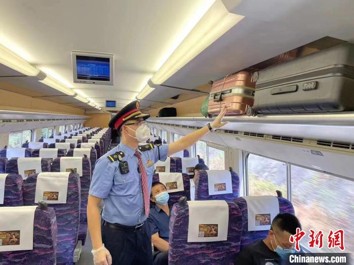 圖為9月5日，D1797列車上，工作人員為旅客整理行李架。　張文杰 攝