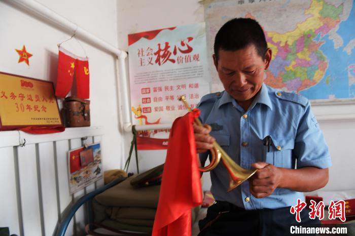 圖為謝建民整理當(dāng)兵時(shí)的小號(hào)。　胡東育 攝