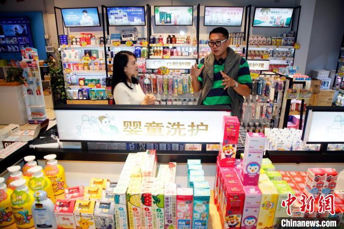 阿樂(圖右)向臺灣青年陳立晴傳授選貨經(jīng)驗。　湯彥俊 攝