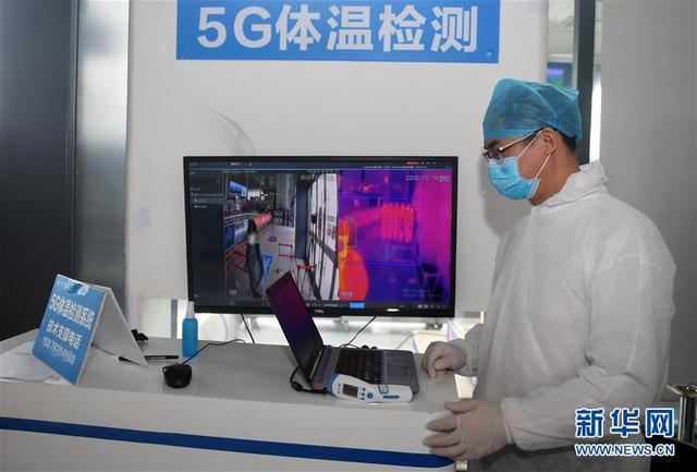 在廣西南寧東站，工作人員運(yùn)用5G體溫檢測(cè)系統(tǒng)對(duì)進(jìn)站旅客進(jìn)行測(cè)溫。新華社記者 陸波岸攝