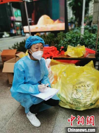 陳福珍在南明區(qū)花果園花中社區(qū)參與志愿工作登記醫(yī)療物資?！∥榇喝A供圖