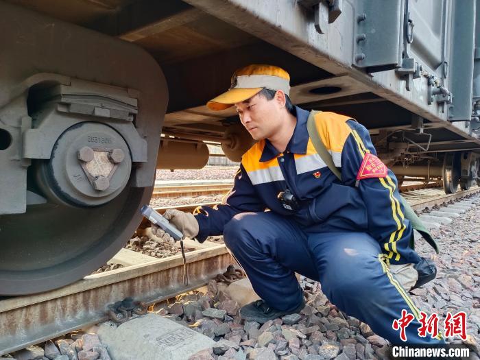 圖為張建亮在檢查車輛軸承溫度。　朱俊麟 攝